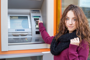 Young woman using ATM